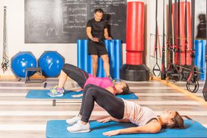 Women doing pelvic exercise with trainer in gym